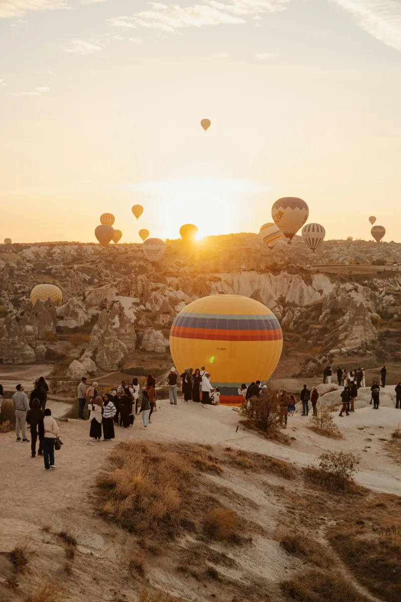 Hot air balloons flying over Cappadocia fairy chimneys at sunrise, Turkey