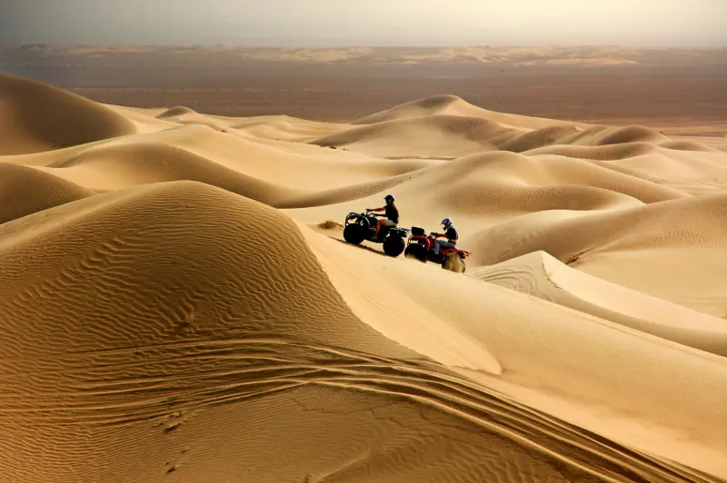Tourists enjoying dune vehicle drivind in  Dubai desert safari
