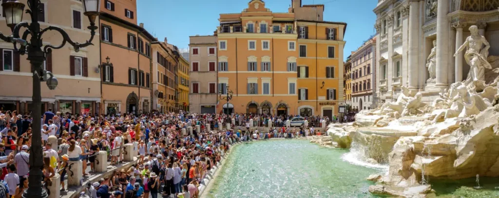 Crowds gathered at the Trevi Fountain on a sunny day in Rome